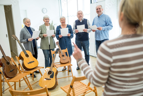 Seniors in retirement home making music singing in choir