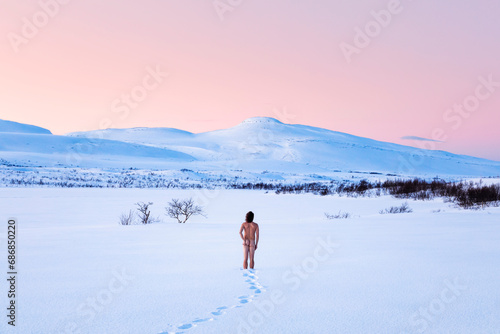 Nude man standing in winter landscape, Lebesby, Norway photo