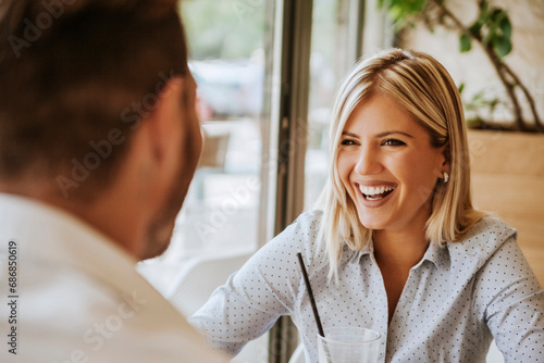 Happy young woman looking at man in a cafe