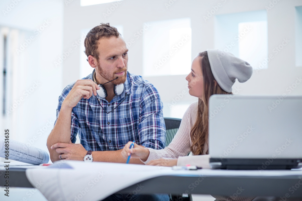 Young man and woman discussing project in design office Young man and woman discussing project in design office
