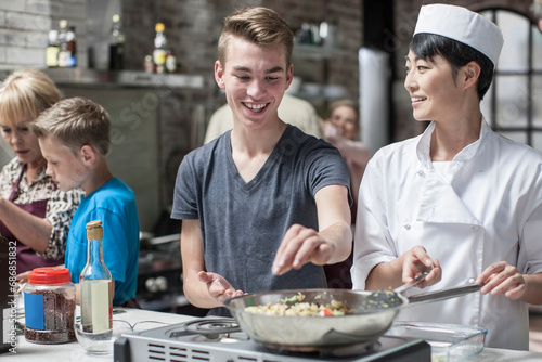 Teenager and female chef cooking together