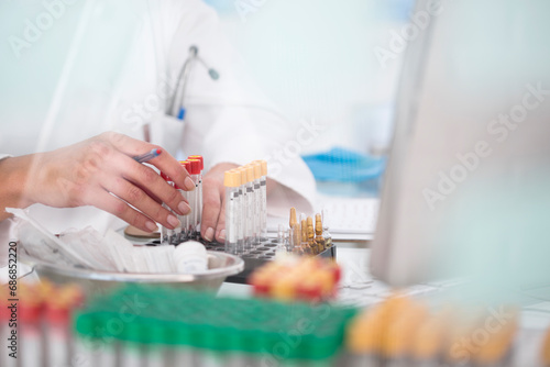 Close-up of lab technician with test tubes and rack in laboratory