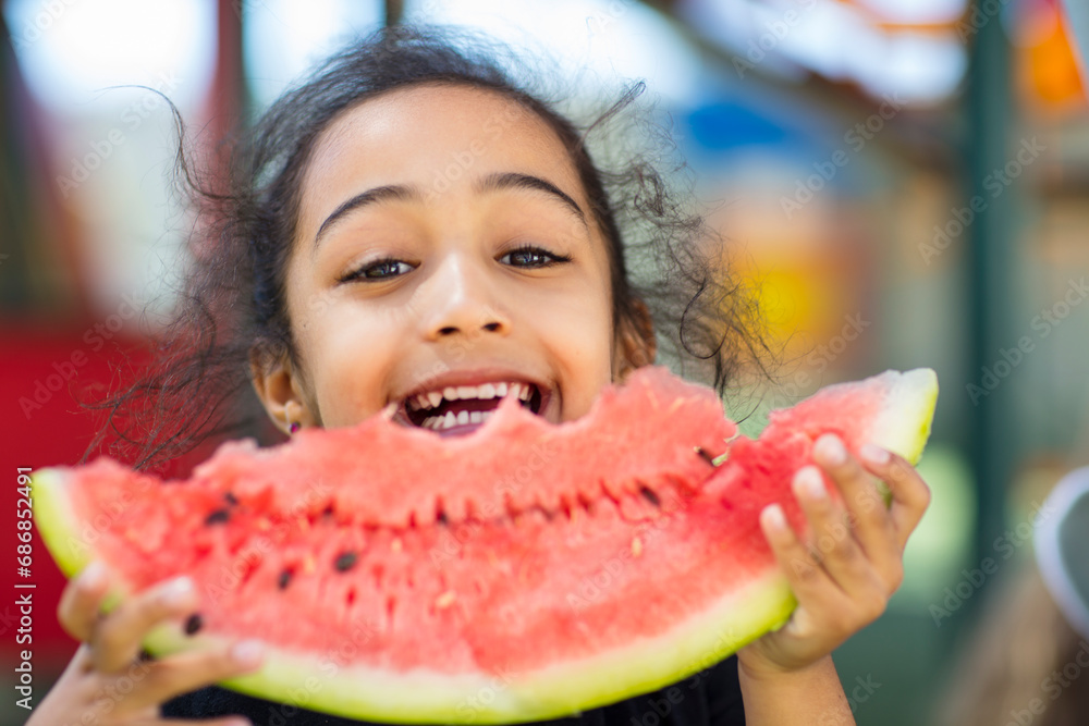 Portrait of happy girl eating a watermelon in kindergarten