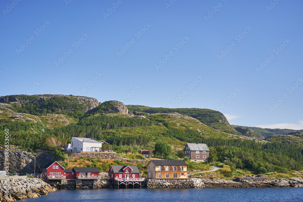 Woden fisherman houses in the Norway, part of scandinavian lifestyle or culture. Traditional pitoresque colourful houses in the fjord by the water line dedicated for processing of catched cod fish.