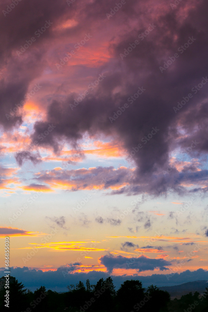 Gentle sky at sunset, sunrise with real sun and clouds. Real majestic sunrise sundown sky background with gentle colorful clouds without birds.