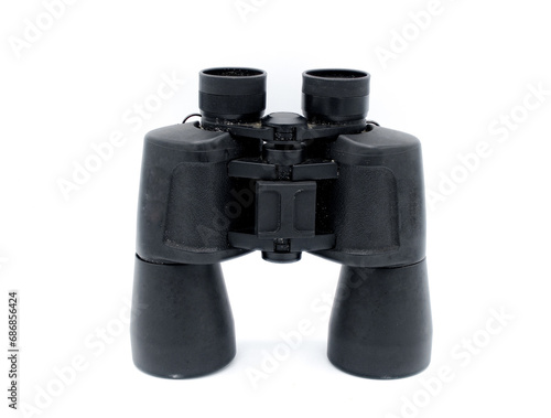A pair of black rubber grip metal binoculars isolated on white background.  Well worn, used, dirty full of sand from being out in the field viewing wildlife.  Top view