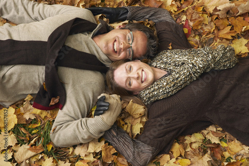 Portrait of Couple Lying Down in Autumn Leaves photo
