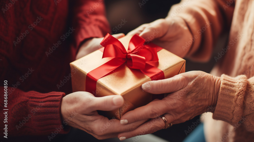 Close up of elderly woman's hands holding present, receiving wrapped gift box from young daughter or grandchild Close up of elderly woman's hands holding present, receiving wrapped gift box from young daughter or grandchild