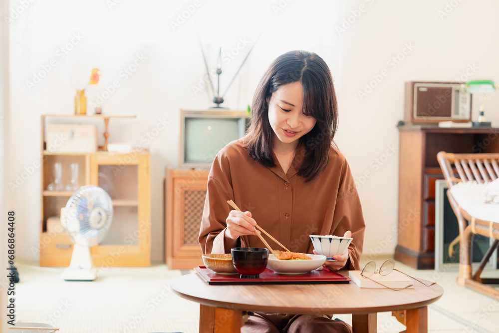 和室でご飯を食べる若い女性
