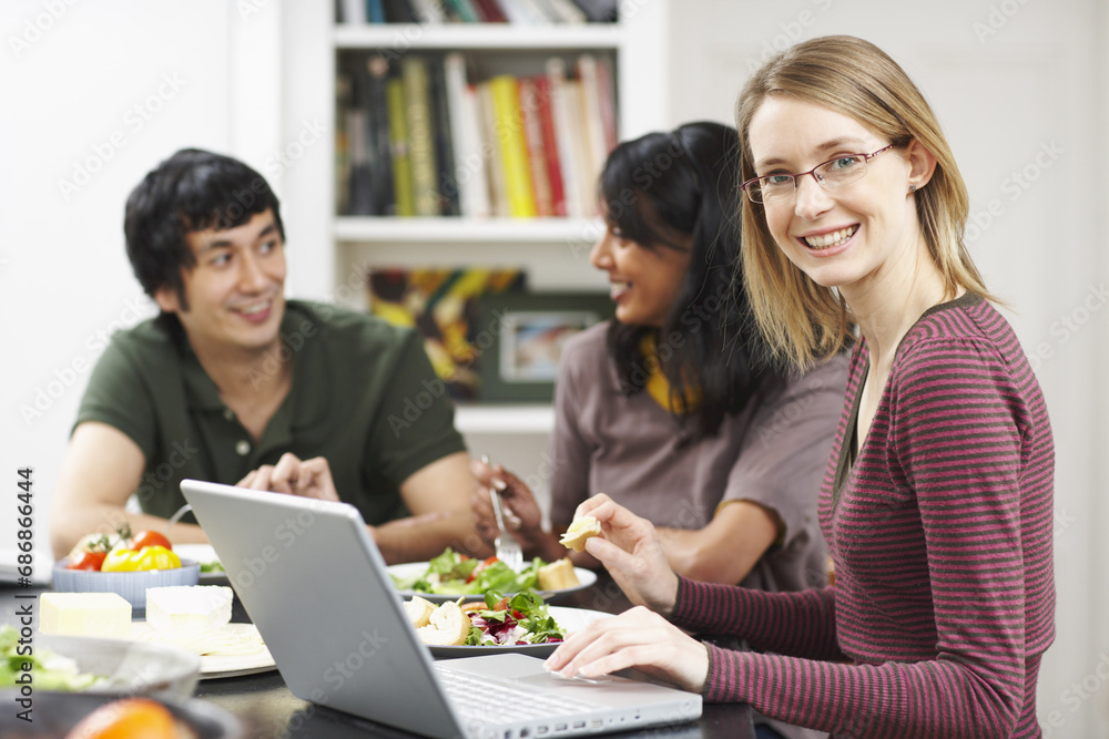 Woman Using Laptop Computer at the Dinner Table