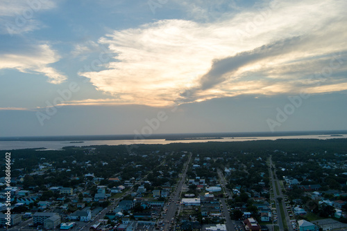 aerial shot of beautiful summer landscape with homes, apartments and condos, cars on the street and lush green trees and grass at sunset in Carolina Beach North Carolina USA