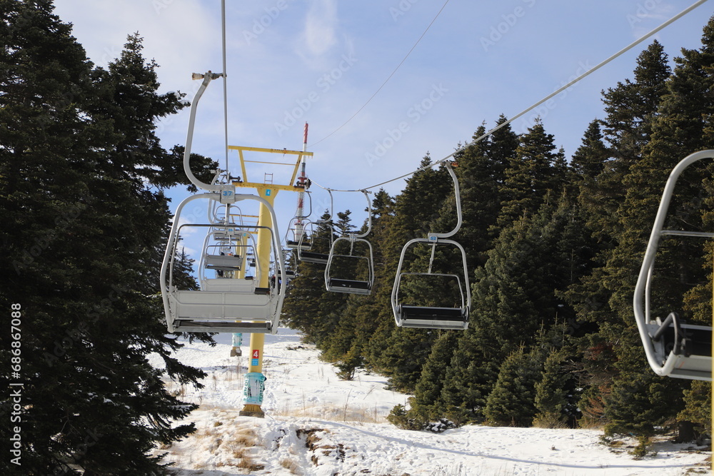 Obraz premium Ski Lift snowy mountain winter forest with chair lift At The Ski Resort in winter. Snowy weather Ski holidays Winter sport and outdoor activities Outdoor tourism, Bursa (Turkey), Uludağ ski lift