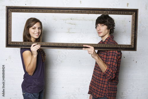 Young Couple Holding Picture Frame photo