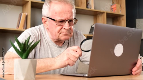 Grandpa with headache working with laptop and documents at home on sofa