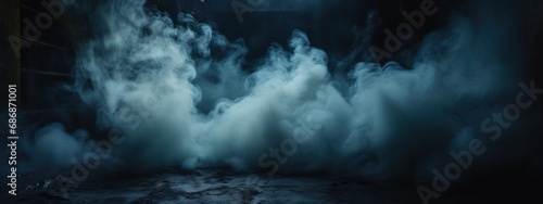 Black stage with blue smoke below, like fog on the floor. In a dark room.