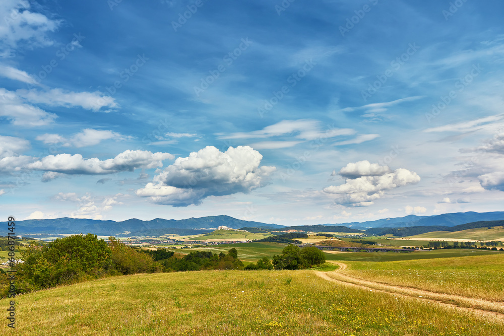 Slovakia summer landscape. Green summer fields, meadows, hills of Tatra mountains. Travel in vacations. Rural Road in Spis region, Slovakia. Spissky hrad national park
