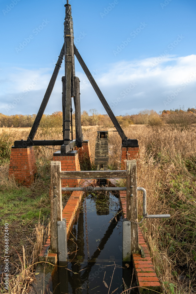 Old, disused and abandoned drainage pump on the riverbank Old, disused and abandoned drainage pump on the riverbank