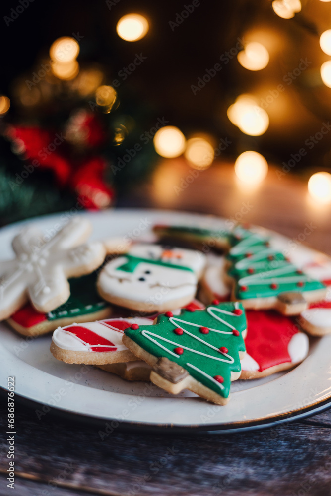 Christmas cookies on sheet or plate with golden lights on rustic table. Baking traditional snowman, tree, star cookies and santa hat. Christmas cookies on sheet or plate with golden lights on rustic table. Baking traditional snowman, tree, star cookies and santa hat.