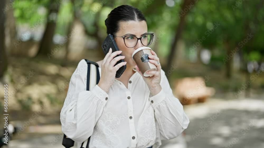 Young beautiful hispanic woman using smartphone drinking take away coffee at the park Young beautiful hispanic woman using smartphone drinking take away coffee at the park
