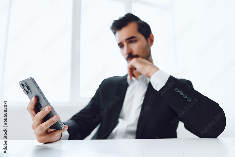 Man in office businessman sitting at desk and working in laptop and talking on phone, modern suit, finance and startup concept and data analysis, working lifestyle in bright office. Man in office businessman sitting at desk and working in laptop and talking on phone, modern suit, finance and startup concept and data analysis, working lifestyle in bright office.