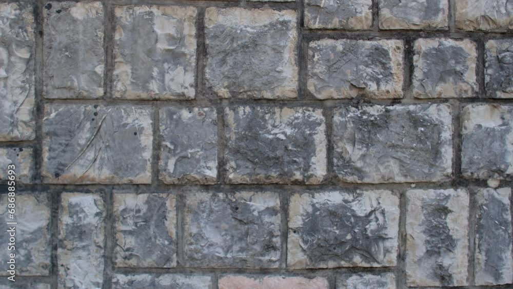 Close-up view of a stone wall reveals intricate details and textures, showcasing the rugged and weathered nature of the surface. Sturdiness and durability of the stone structure. Close-up view of a stone wall reveals intricate details and textures, showcasing the rugged and weathered nature of the surface. Sturdiness and durability of the stone structure.