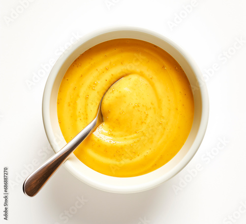 Mustard sauce and spoon isolated on white background, top view