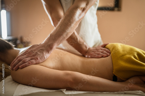 unknown woman enjoy back massage at beauty spa male therapist