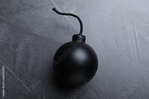 Sphere shaped bomb with burning fuse on black background, top view