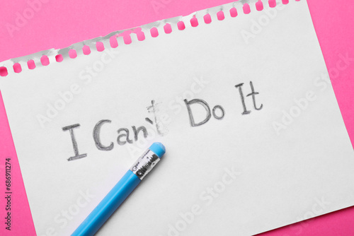 Motivation concept. Paper with changed phrase from I Can't Do It into I Can Do It by erasing letter T on pink background, top view