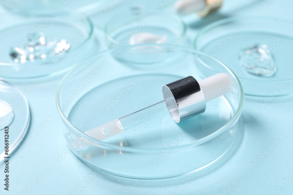 Petri dish and pipette with cosmetic serum on light blue background, closeup Petri dish and pipette with cosmetic serum on light blue background, closeup