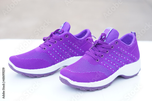 Pair of new purple sneakers. Fashionable and comfortable sport footwears. outdoor background.  Concept, shoes for doing sport or exercise also can wear for traveling, hiking.    photo