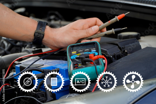 Car care maintenance and servicing.technician checks the battery using a voltmeter capacity tester,