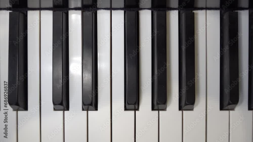A self-playing piano, also called a pianola, with black and white keys playing a tune automatically. A self-playing piano, also called a pianola, with black and white keys playing a tune automatically.