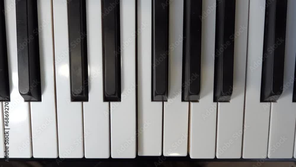 A self-playing piano, also called a pianola, with black and white keys playing a tune automatically. A self-playing piano, also called a pianola, with black and white keys playing a tune automatically.