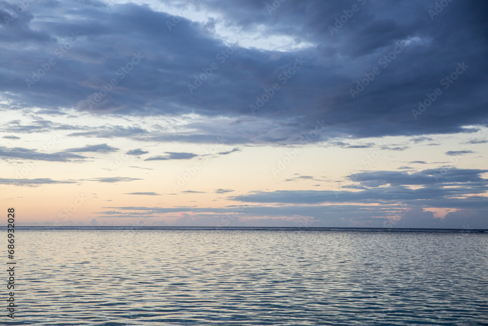 Sunset over the ocean in Tahiti with a blue cloudy stormy sky relaxing and peaceful Sunset over the ocean in Tahiti with a blue cloudy stormy sky relaxing and peaceful
