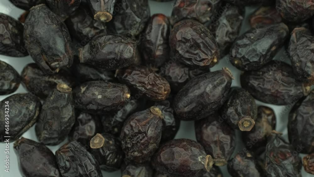 Dried rose hips slowly spinning on a black background. Selective sharpening. Close-up. Dried rose hips slowly spinning on a black background. Selective sharpening. Close-up.