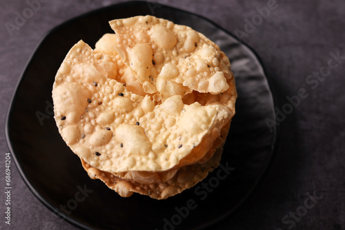 Papadam a traditional indian snack. papad or papadum in raw dried form with roasted cone roll and flat variation photo