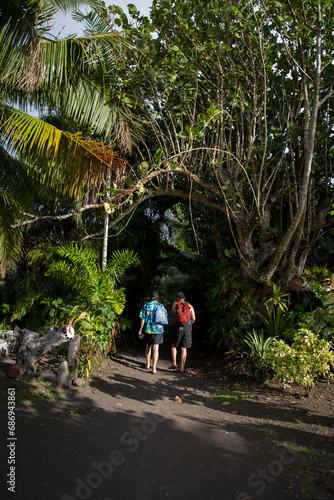 Two friends walk down a tropical path in Tahiti 