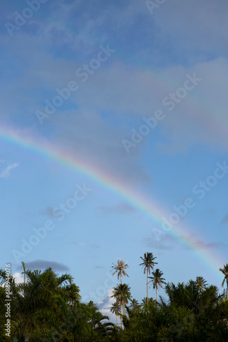 A colorful rainbow over the ocean waves at sunset in Tahiti 