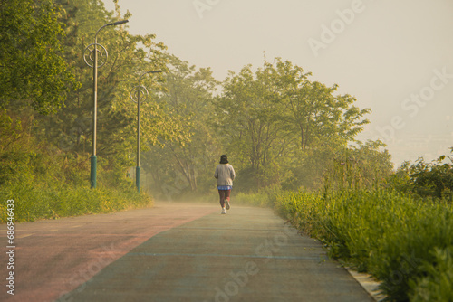 A woman running on a trail covered in early morning fog