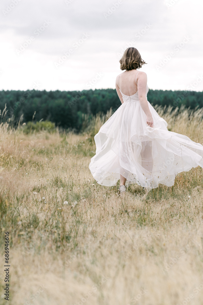Bride running in dress through a field