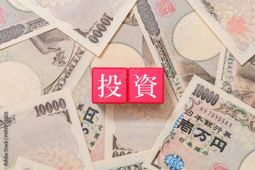 赤色のブロックに書かれた投資の文字　一万円札 photo