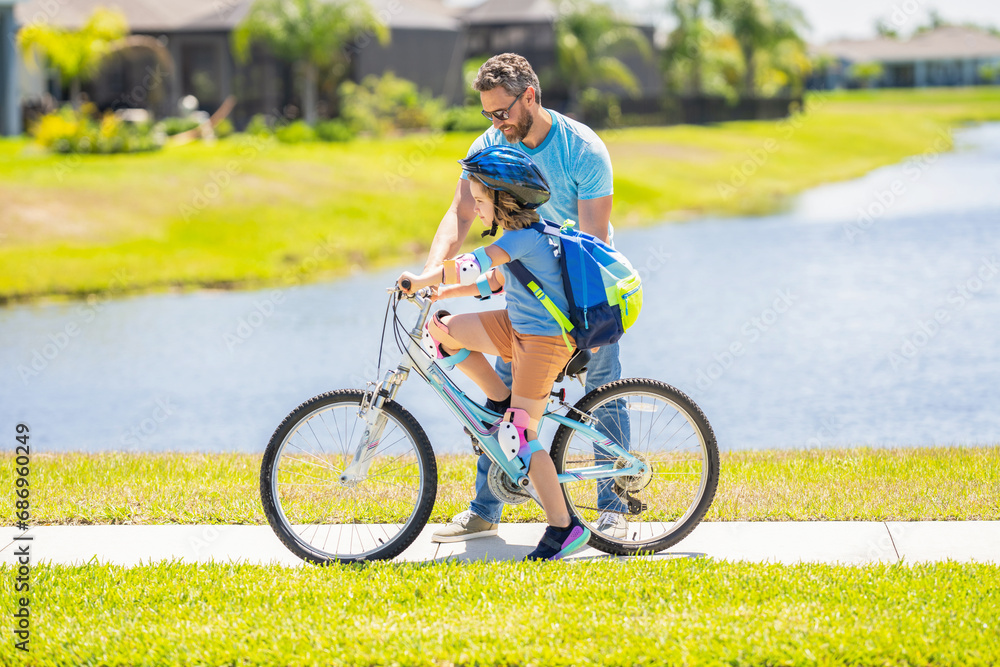 Obraz premium dad and son enjoying fun bike outing. dad and son on biking adventure. dad and son duo pedaling through picturesque landscape. Meaningful family interactions. dad guiding his son first bike ride