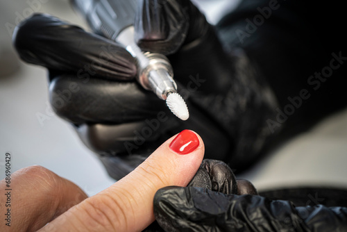 Man manicure. The process of coloring nails on men's fingers in a beauty salon. Manicurist girl gives a guy a manicure. close up nail sawing photo