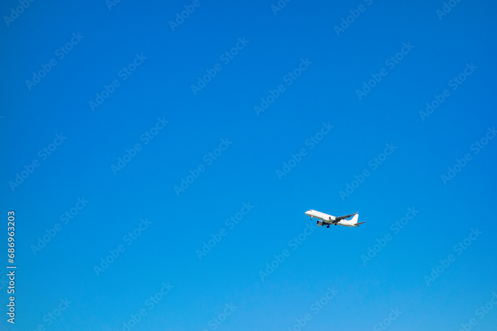 Fototapeta premium 青空を背景に飛行する飛行機