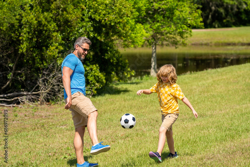 daddy with son improve fatherhood. Outdoor adventures of daddy and son fatherhood together. football family team of father and son. soccer football. Fatherhood in outdoor of daddy and son kid