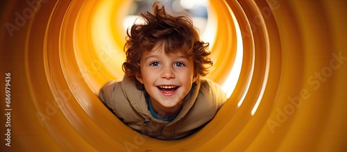 Fototapeta Naklejka Na Ścianę i Meble -  Playful child boy or kid in playground tunnel.