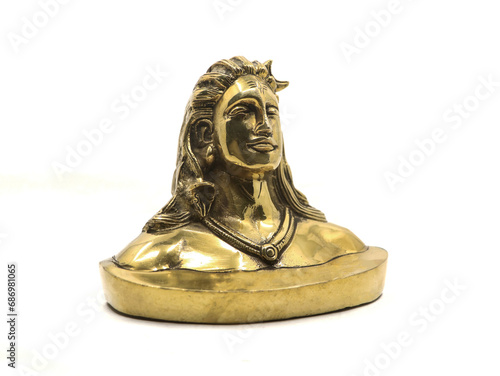 shiny golden idol of lord shiva of hindu religion, antique replica model handcrafted in brass based on adiyogi statue, for car dashboard isolated in a white background photo