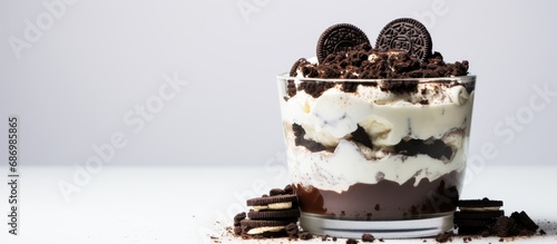 Homemade Oreo trifle: Vanilla chocolate cookie layered cheesecake variation in a glass. photo