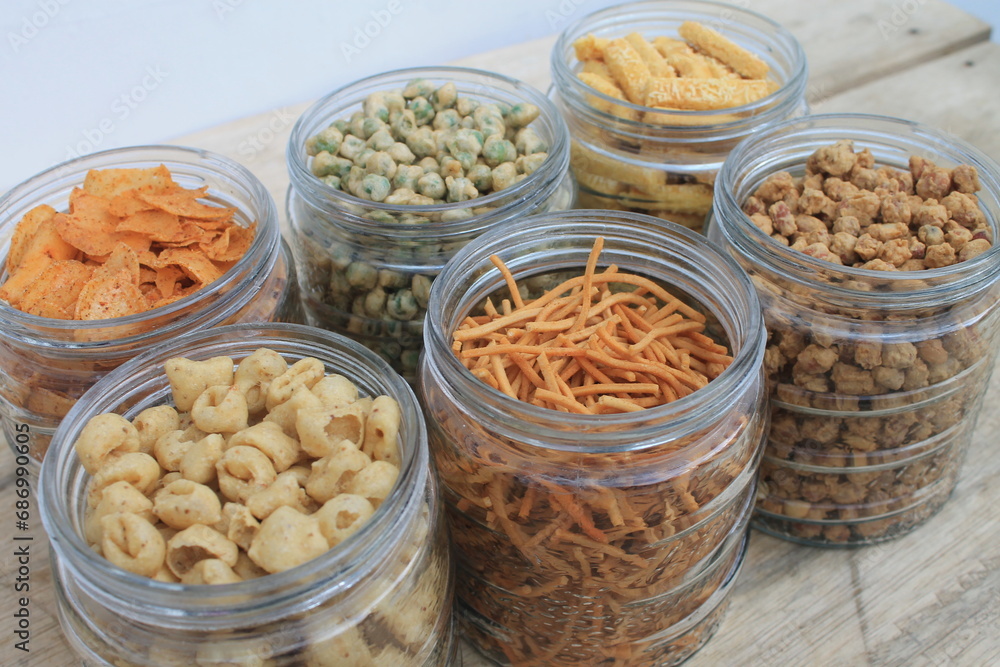 Rows of Indonesian various snacks in jars on the table Rows of Indonesian various snacks in jars on the table